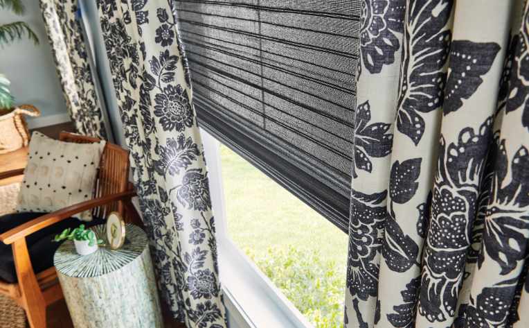 close up image of blue patterned curtains over gray blinds in living space